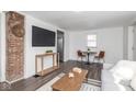 Open-concept living room with a table set for two, a modern television, and hardwood floors at 4814 Southeastern Ave, Indianapolis, IN 46203