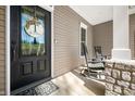 A close up of the front door, porch chairs, stone support pillars and wreath at 4955 N 500 W, Columbus, IN 47201