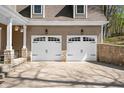 Close up of the two car garage with black hardware, white doors, and stone accents on the pillars at 4955 N 500 W, Columbus, IN 47201