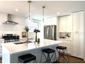 Bright, remodeled kitchen with a large center island, stainless steel appliances and modern lighting at 5135 N Kenwood Ave, Indianapolis, IN 46208