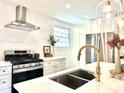 Close up of modern kitchen, featuring white cabinets, quartz countertops, and stainless steel appliances at 5135 N Kenwood Ave, Indianapolis, IN 46208