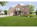 Charming brick two-story home with landscaped front yard and covered entryway at 5698 Kenderly Ct, Carmel, IN 46033
