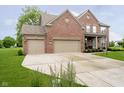 Brick two-story home features an attached three-car garage and a well-maintained lawn at 5698 Kenderly Ct, Carmel, IN 46033