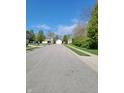 Neighborhood street view with well-kept lawns and various home styles under a blue sky at 5912 Accent Dr, Indianapolis, IN 46221