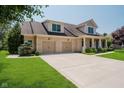 View of brick home with attached two-car garage, lush lawn, and mature landscaping at 6345 Canak Dr, Avon, IN 46123