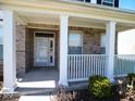Inviting front porch features brick accents, white columns, and a white railing, creating a cozy outdoor space at 7150 Pheasant Ridge Dr, Indianapolis, IN 46237