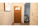 Inviting entryway featuring white plank walls, a half-round wood door, and a view into the living space at 8035 Black Oak Ct, Plainfield, IN 46168