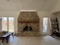 Spacious living room with a brick fireplace, large windows, and neutral tile flooring at 8502 Jib Ct, Indianapolis, IN 46236