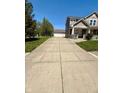 Long concrete driveway leading to a detached garage and a beautiful two-story home at 8830 Kipling Dr, Indianapolis, IN 46239