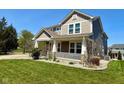 Beautifully landscaped front yard with a charming two-story home and inviting covered porch at 8830 Kipling Dr, Indianapolis, IN 46239