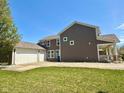 Back exterior with a detached garage, a spacious yard and an elevated porch at 8830 Kipling Dr, Indianapolis, IN 46239