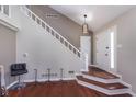 Inviting entryway with hardwood floors, white staircase, and stylish pendant lighting at 9162 Cinnebar Dr, Indianapolis, IN 46268