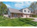 Lovely two-story townhome featuring brick and siding exterior, an attached two-car garage, and a lush green lawn at 9162 Cinnebar Dr, Indianapolis, IN 46268