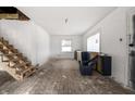 Bright living room with unfinished staircase, offering great renovation potential at 940 N Chester Ave, Indianapolis, IN 46201