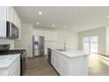 Bright, modern kitchen with stainless steel appliances, white cabinets, and a large center island at 9734 Behner Dr, Fishers, IN 46250