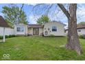 Spacious backyard with a large grassy area, mature trees, and a quaint patio at 1002 Prairie Depot, Indianapolis, IN 46241