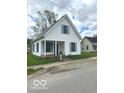 Quaint two-story home featuring a covered porch and well-kept lawn, radiating a cozy charm at 11 W Osage St, Greenfield, IN 46140