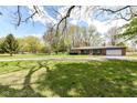 Spacious front yard and brick ranch style home with a large driveway at 1101 Oakwood Trl, Indianapolis, IN 46260