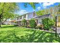 Lovely home with brick and siding exterior, surrounded by green lawn and manicured bushes at 12669 Brookshire Pkwy, Carmel, IN 46033