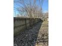 Large backyard is enclosed by a wooden fence that ensures privacy and has trees at 1342 W Lee St, Indianapolis, IN 46221
