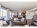 Open-concept living room with stylish furniture and hardwood floors leading to a modern kitchen at 1370 Timber Bluff Rd, Westfield, IN 46074