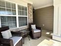 Relaxing front porch featuring comfortable wicker seating, a small table, and a view of the neighborhood at 16869 Cimarron Pass, Noblesville, IN 46060