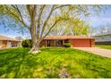 Well-kept brick home with mature trees, lush green lawn, and a cozy, inviting feel at 1908 Roundhill Dr, Anderson, IN 46013