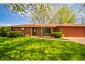 Inviting brick home with well-maintained lawn, mature landscaping, and a welcoming entrance at 1908 Roundhill Dr, Anderson, IN 46013
