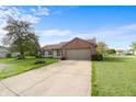 Charming single-story home featuring a brick accent wall, attached garage and a driveway at 2102 Coldwater Cir, Indianapolis, IN 46239