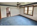View of a living room with hardwood trim, carpet, a ceiling fan, and natural light at 2309 Pennsylvania St, Columbus, IN 47201