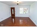 Bright living room features gleaming hardwood floors, fresh white walls, and natural light from the window at 233 N Fenton Ave, Indianapolis, IN 46219