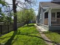 A backyard view of a home with a green lawn, wooden fence, trees and a shed at 2819 W 16Th St, Indianapolis, IN 46222