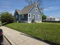 Exterior side view of home with blue siding, white trim, grass lawn, and paved sidewalk at 2819 W 16Th St, Indianapolis, IN 46222