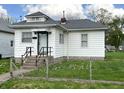A quaint house with white siding, a dark roof, concrete steps, and a simple, functional front entrance at 3434 Forrest Ter, Anderson SE, IN 46013