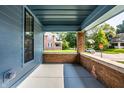 Inviting covered porch, showcasing brick supports and a glimpse of the neighborhood at 3868 N Park Ave, Indianapolis, IN 46205