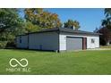 Detached garage with gray siding and gray garage door, green lawn at 4006 Kenneth Ave, Indianapolis, IN 46226