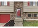 Close up of a home's red front door and address number, framed by brick and light-colored siding at 5335 Honey Comb Ln, Indianapolis, IN 46221