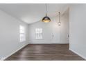 Inviting living room featuring vaulted ceilings, stylish pendant lighting, and beautiful hardwood flooring at 5622 Imperial Woods Cir, Indianapolis, IN 46224