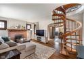 Open living room featuring a cozy fireplace and a unique spiral staircase at 5697 Broadway St, Indianapolis, IN 46220