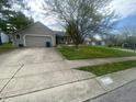 Ranch-style home with an attached garage and a well-manicured lawn featuring some small trees at 6011 Mcclellan Ct, Indianapolis, IN 46254