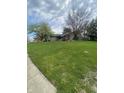 Well-kept lawn with a charming ranch-style home featuring an attached garage and a welcoming front porch at 6011 Mcclellan Ct, Indianapolis, IN 46254