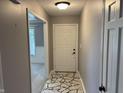 A welcoming entryway features a unique stone-patterned floor, a white front door, and neutral gray walls at 616 Elbow Bend Blvd, Greenwood, IN 46142
