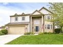 Charming two-story home with a well-maintained lawn, an attached two-car garage, and a classic facade at 6164 Parrington Dr, Indianapolis, IN 46236
