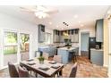 Bright kitchen boasts grey cabinets, island with seating, stainless appliances, and access to the back deck through sliding door at 6164 Parrington Dr, Indianapolis, IN 46236