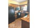 Cozy kitchen with wood cabinets, black appliances, and butcher block countertops at 650 Balroyal Ct, Indianapolis, IN 46234