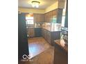 Traditional kitchen featuring wood cabinets, black appliances, and wood flooring at 650 Balroyal Ct, Indianapolis, IN 46234