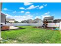 Expansive backyard featuring a patio, grassy area, and a playset, ideal for Gathering fun and relaxation at 6827 Fallen Leaf Dr, Whitestown, IN 46075