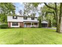 Inviting two-story home with a charming porch, well-manicured lawn, and attached garage, perfect for families at 7140 Avalon Trail Dr, Indianapolis, IN 46250