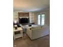 Cozy living room featuring a brick fireplace, built-in shelving, and a french door to the exterior at 7140 Avalon Trail Dr, Indianapolis, IN 46250