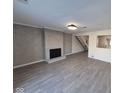Spacious living room with a decorative fireplace, modern flooring, and an open layout to the staircase at 7368 Country Brook Dr # 7368, Indianapolis, IN 46260
